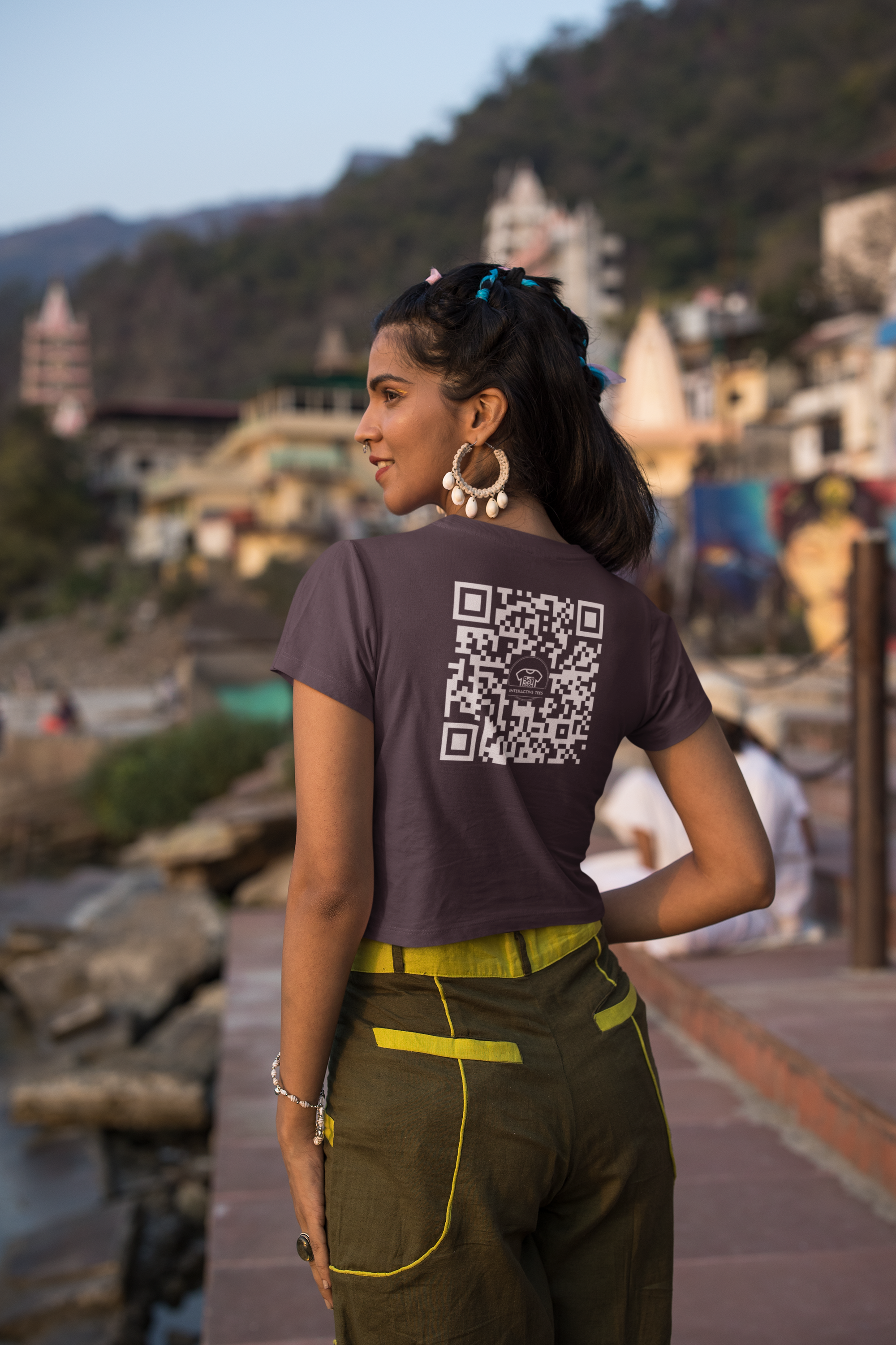 Woman in a dark purple teeshirt with a QR code that redirects to a rick roll video on youtube